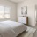 bright bedroom with a bed and a fan