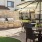a patio with a grill and chairs